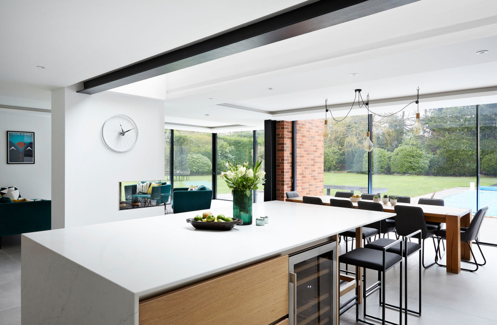 Expansive scandinavian open plan kitchen in Surrey with a double-bowl sink, flat-panel cabinets, white cabinets, quartzite benchtops, white splashback, porcelain floors, with island, grey floor and white benchtop.