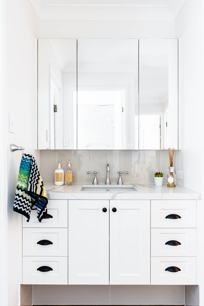 Design ideas for a transitional bathroom in Brisbane with shaker cabinets, white cabinets, gray tile, white walls, an undermount sink and white benchtops.