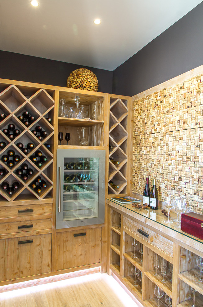 This is an example of a mid-sized contemporary wine cellar in Marseille with diamond bins and light hardwood floors.