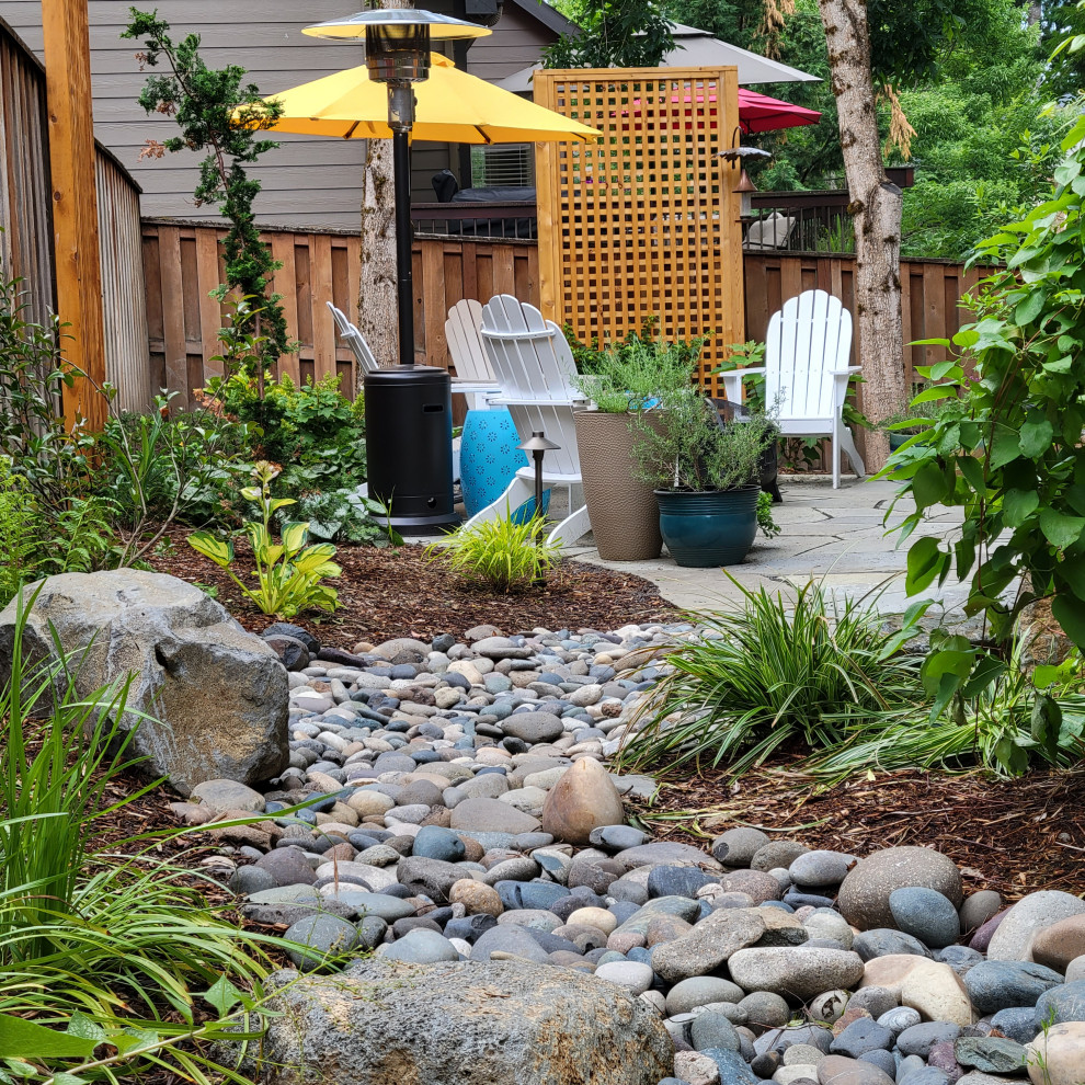 This is an example of a medium sized rustic back partial sun garden for summer in Portland.
