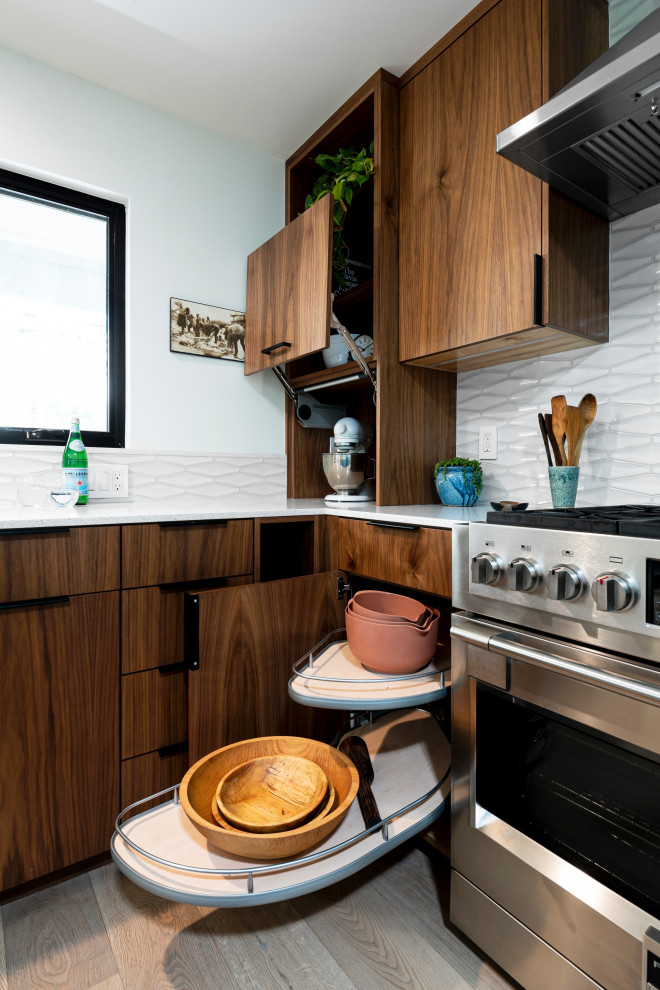 Inspiration for a large midcentury l-shaped eat-in kitchen in Sacramento with flat-panel cabinets, medium wood cabinets, quartz benchtops, grey splashback, porcelain splashback, stainless steel appliances, with island and white benchtop.