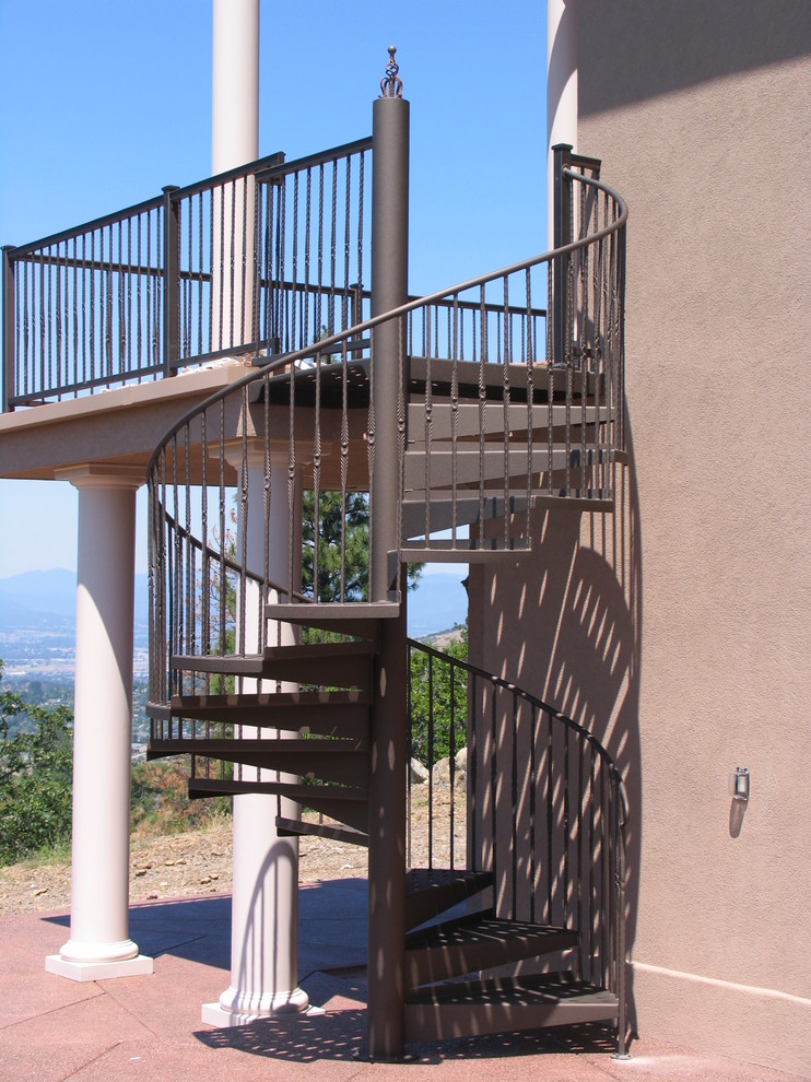 This is an example of a mid-sized mediterranean metal curved staircase in Other with open risers and metal railing.