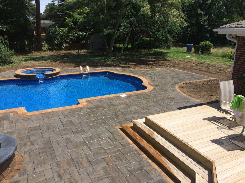 Example of a large transitional backyard concrete paver and custom-shaped hot tub design
