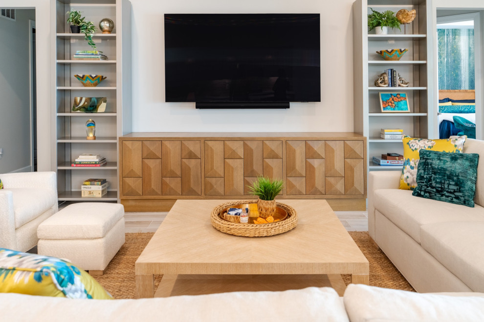 Diseño de salón cerrado minimalista de tamaño medio con suelo de madera en tonos medios, televisor colgado en la pared y paredes beige