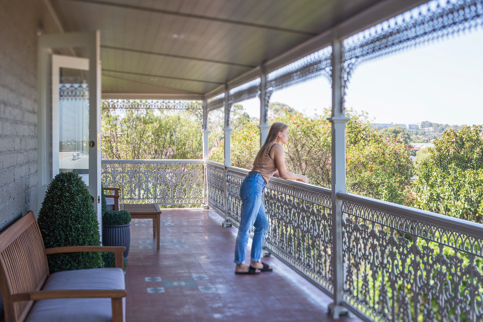 This is an example of a mid-sized traditional balcony in Sydney with a roof extension.