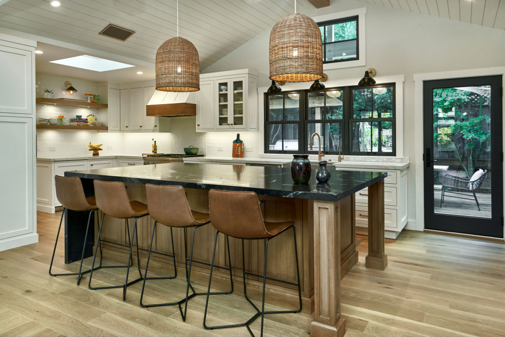 Design ideas for a large rural u-shaped open plan kitchen in San Francisco with a belfast sink, beaded cabinets, white cabinets, quartz worktops, white splashback, ceramic splashback, light hardwood flooring, an island, grey floors, white worktops, a vaulted ceiling, a timber clad ceiling and stainless steel appliances.