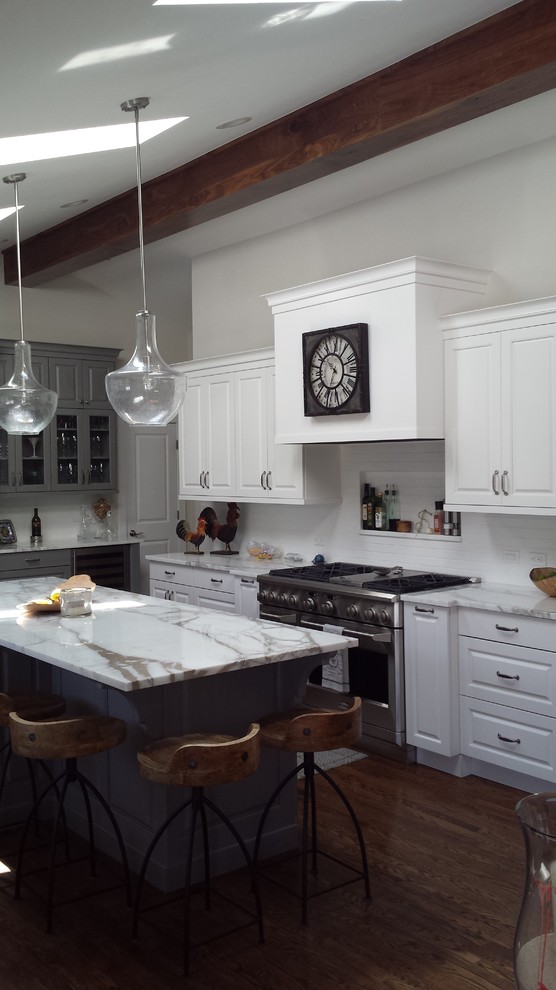 Open concept kitchen - mid-sized rustic u-shaped dark wood floor open concept kitchen idea in Denver with an integrated sink, raised-panel cabinets, white cabinets, marble countertops, white backsplash, subway tile backsplash, stainless steel appliances and an island