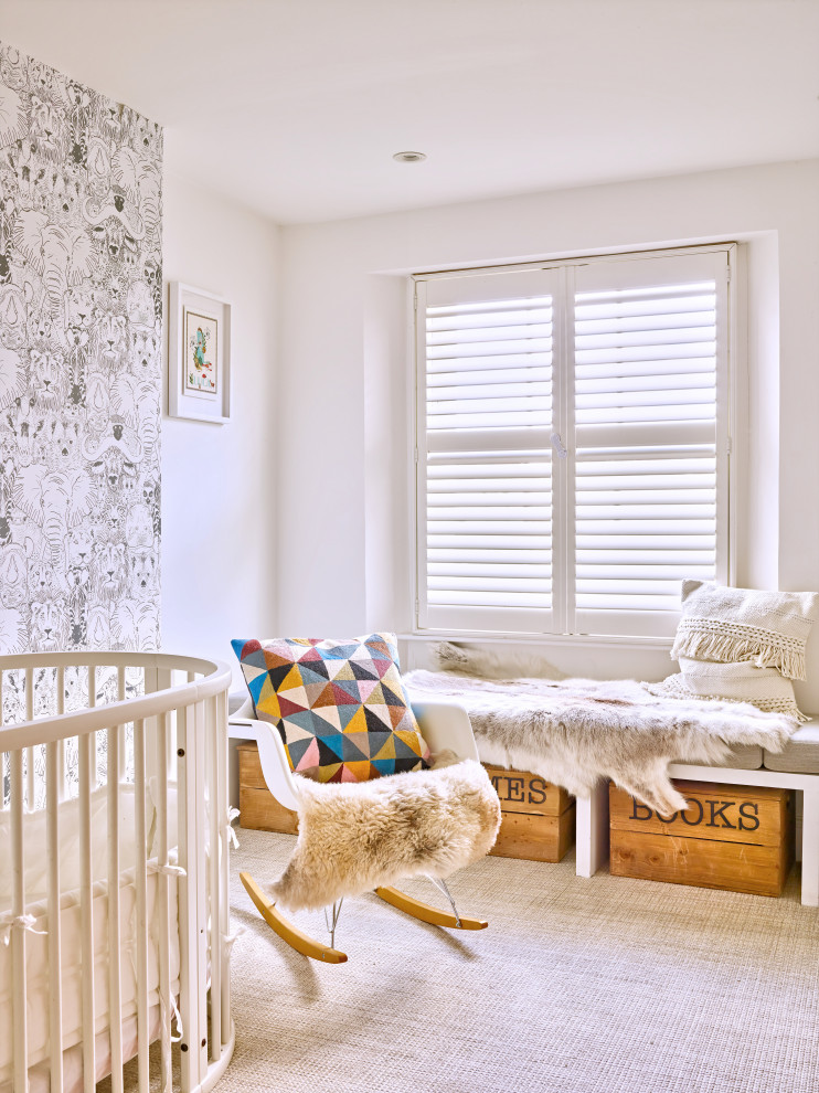 This is an example of a transitional nursery in London with white walls, carpet and grey floor.