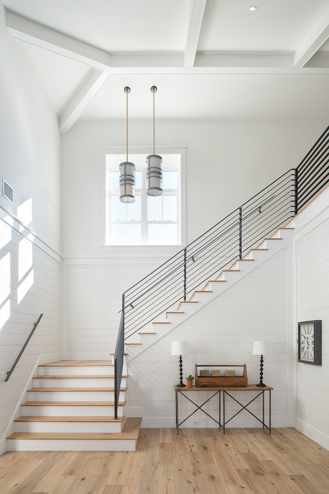 This is an example of a country wood l-shaped staircase in Tampa with painted wood risers and metal railing.