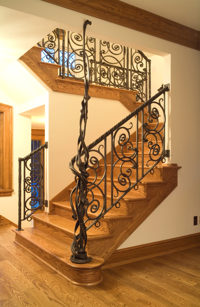 Mediterranean wood staircase in Milwaukee with wood risers and metal railing.