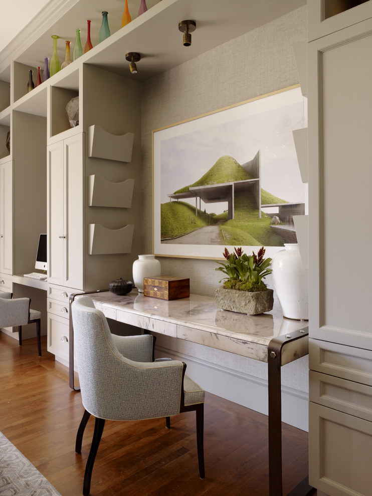 This is an example of a contemporary home office in San Francisco with beige walls and medium hardwood floors.