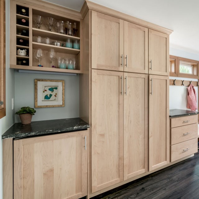 This is an example of a small contemporary single-wall dry bar in Columbus with shaker cabinets, light wood cabinets, granite worktops, vinyl flooring, grey floors and black worktops.