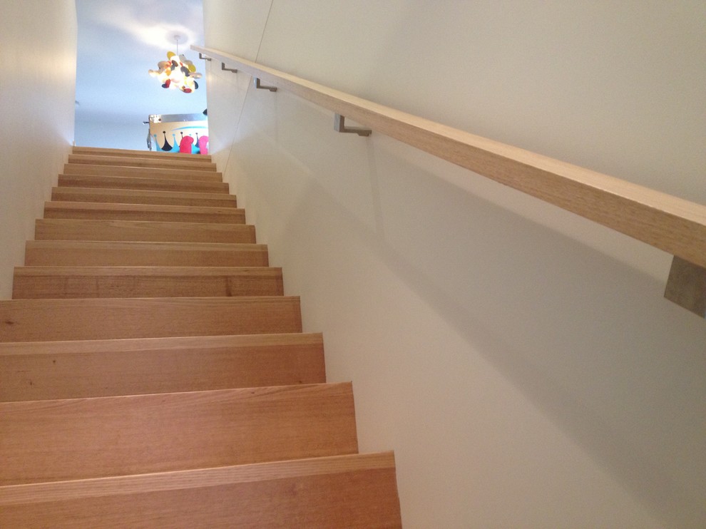 This is an example of a contemporary wood straight staircase in Melbourne with wood risers.