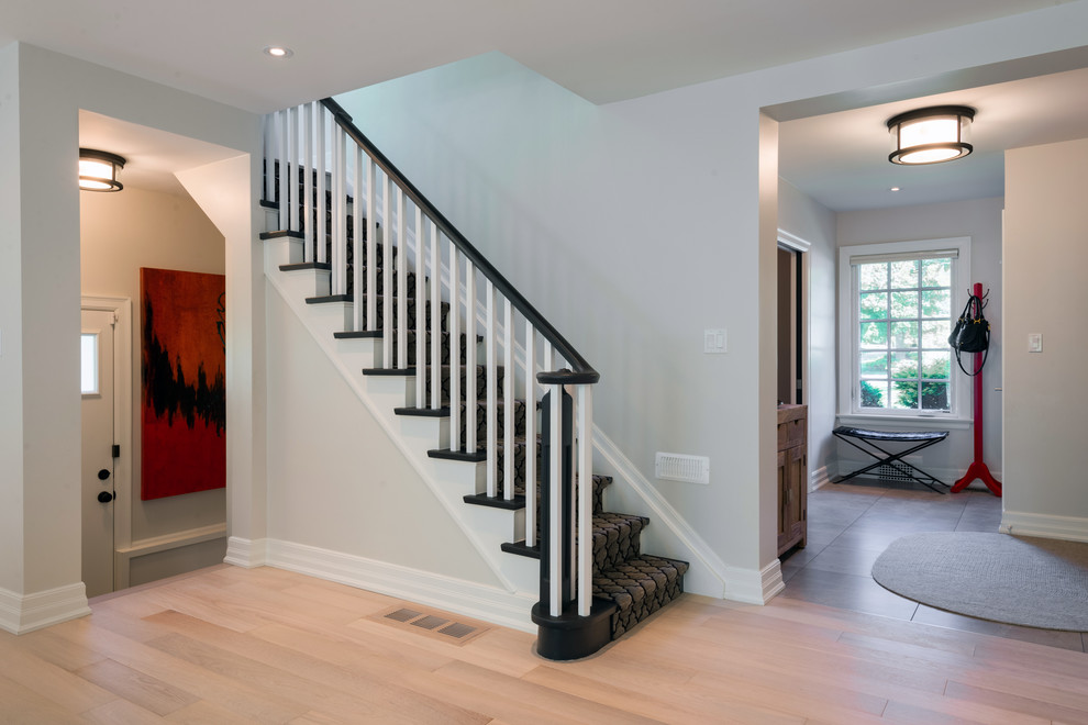 This is an example of a mid-sized contemporary painted wood u-shaped staircase in Toronto with painted wood risers.