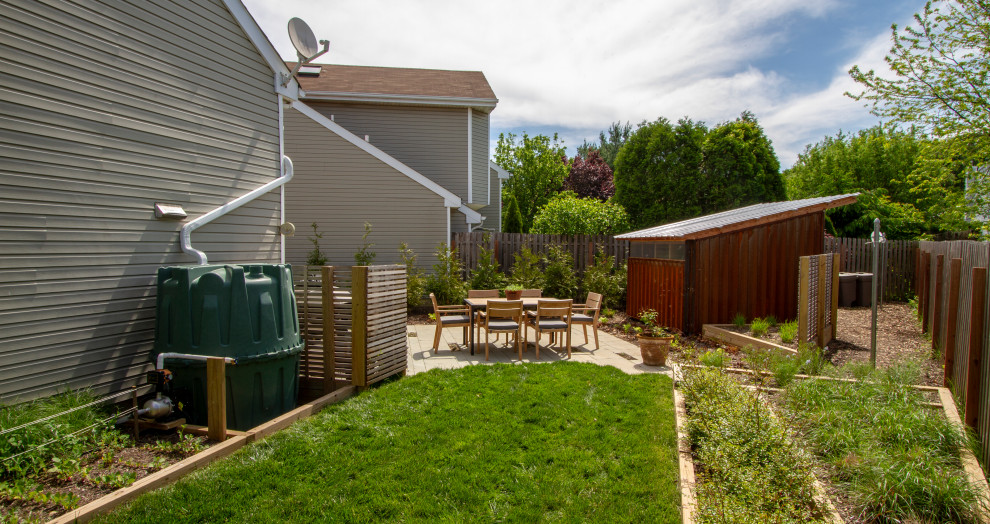 Mid-sized modern side yard full sun xeriscape in New York with a vegetable garden and concrete pavers for summer.
