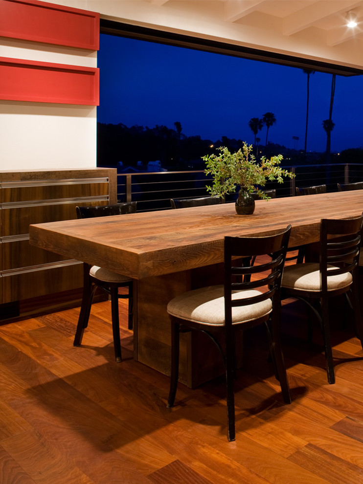 This is an example of a midcentury dining room in Orange County with dark hardwood floors.