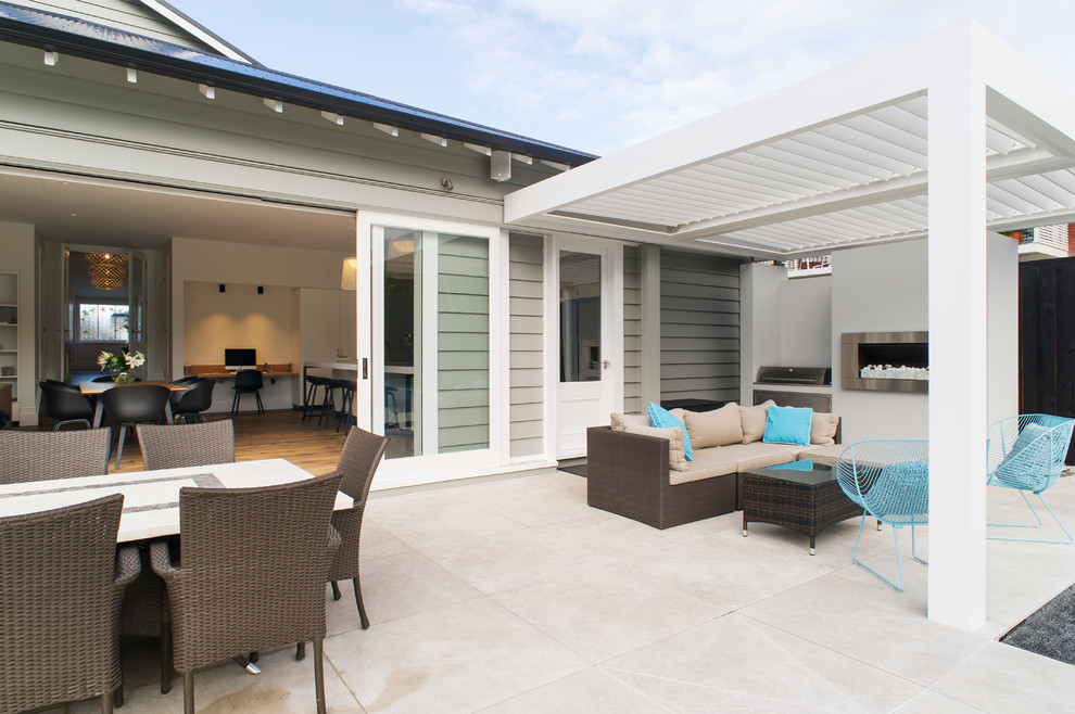 Inspiration for a backyard verandah in Auckland with a fire feature, tile and a pergola.