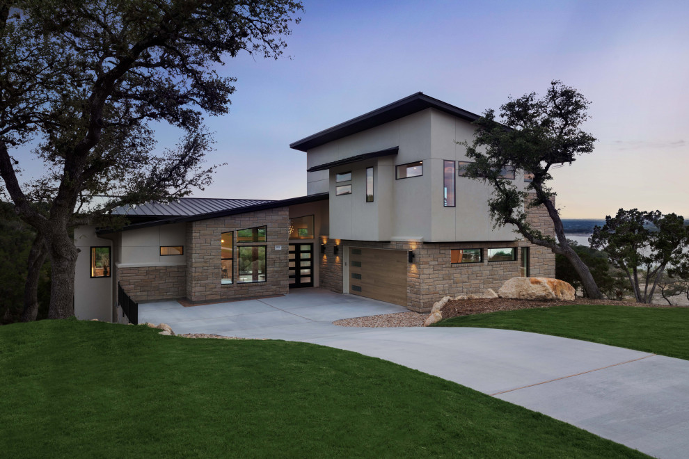 Trendy white three-story stucco house exterior photo in Austin with a shed roof and a black roof