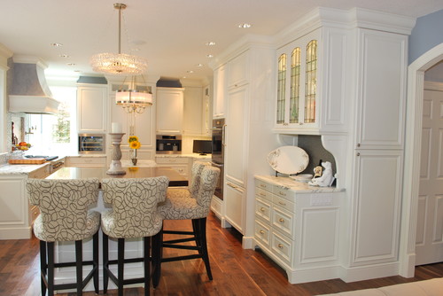 Traditional modern kitchen with white cabinets and hardwood flooring featuring four stools with patterned cushions