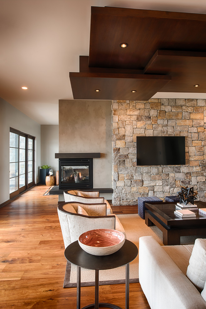 This is an example of a mid-sized contemporary formal open concept living room in Minneapolis with beige walls, medium hardwood floors, a corner fireplace, a metal fireplace surround, a wall-mounted tv and brown floor.