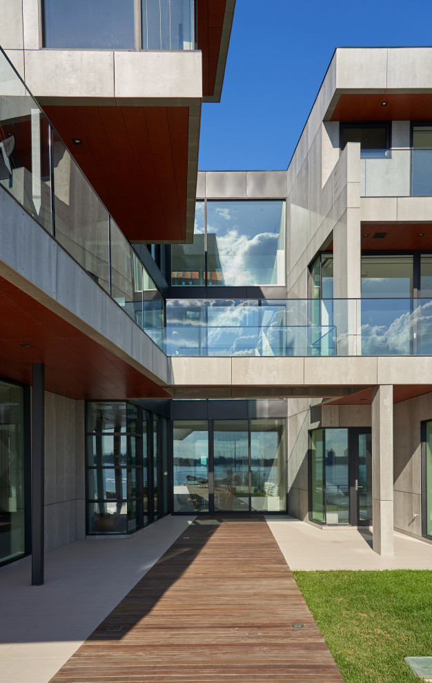 Пример оригинального дизайна: большой, трехэтажный частный загородный дом в стиле модернизм с облицовкой из бетона, плоской крышей и зеленой крышей