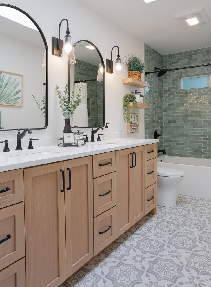 Inspiration for a medium sized coastal family bathroom in Seattle with shaker cabinets, light wood cabinets, an alcove bath, a shower/bath combination, a one-piece toilet, green tiles, metro tiles, white walls, porcelain flooring, a submerged sink, engineered stone worktops, grey floors, a shower curtain, white worktops, double sinks and a built in vanity unit.