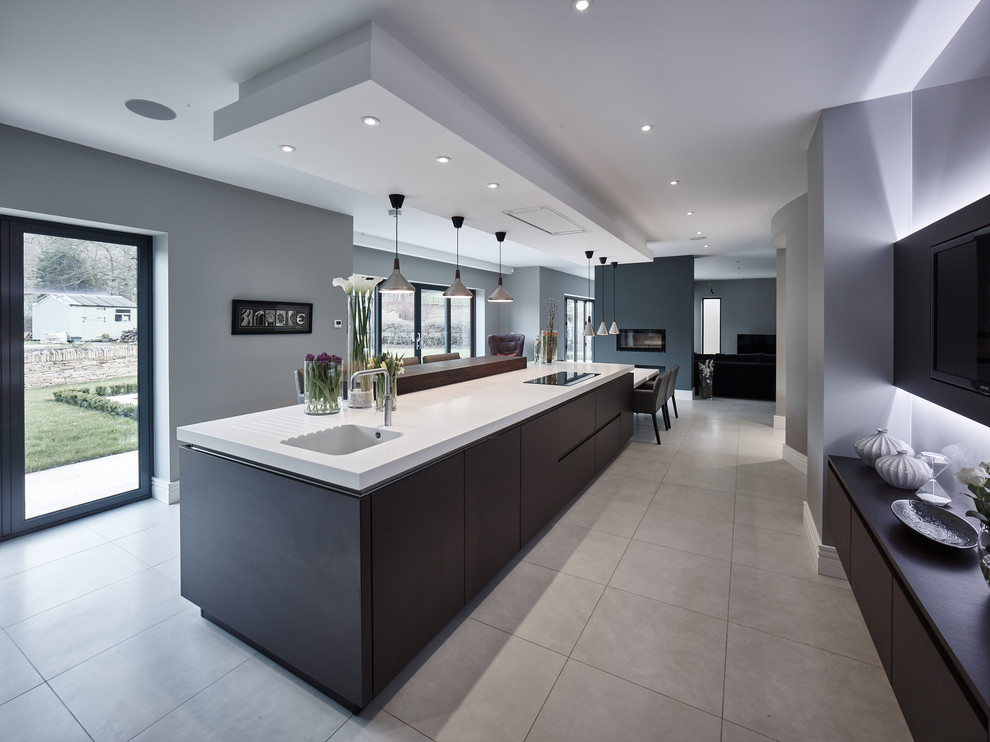 Inspiration for an expansive contemporary single-wall open plan kitchen in Other with flat-panel cabinets, white cabinets, solid surface benchtops, stainless steel appliances, porcelain floors, with island, grey floor and white benchtop.