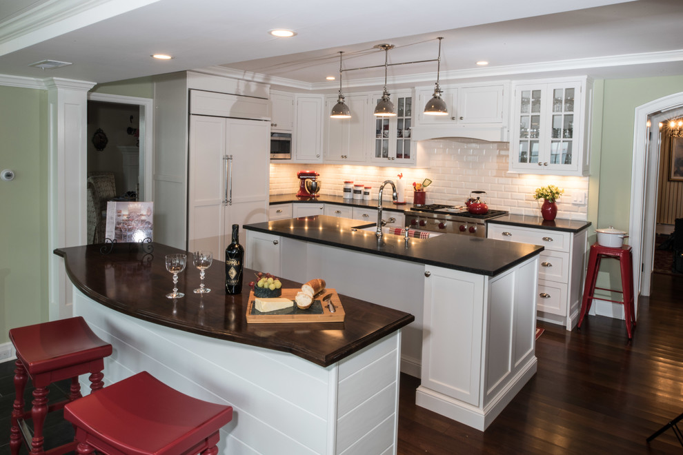 Design ideas for a small transitional l-shaped eat-in kitchen in Baltimore with a farmhouse sink, flat-panel cabinets, white cabinets, granite benchtops, white splashback, ceramic splashback, panelled appliances, medium hardwood floors and multiple islands.
