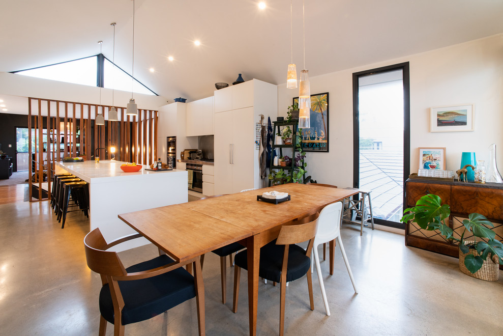Photo of a mid-sized contemporary kitchen/dining combo in Sydney with white walls, concrete floors and grey floor.