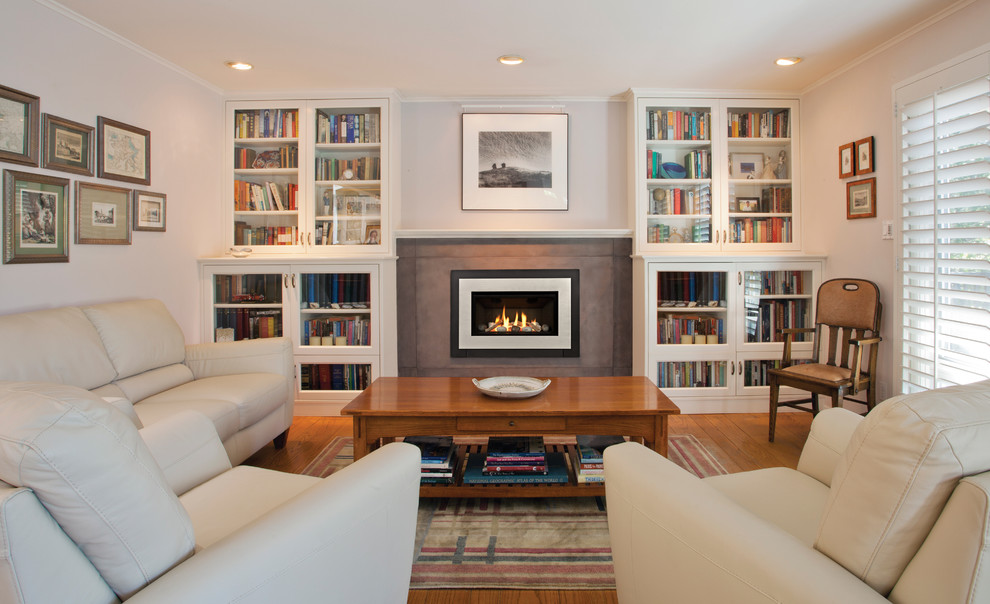Photo of a mid-sized transitional formal enclosed living room in Portland with white walls, dark hardwood floors, a standard fireplace, a concrete fireplace surround and no tv.