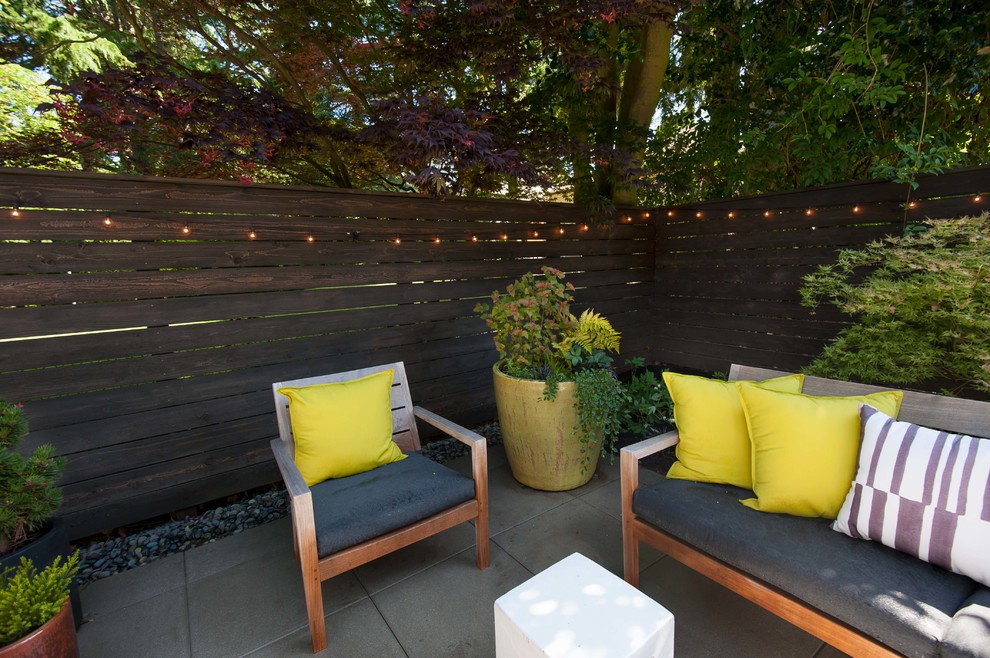 This is an example of a large contemporary backyard partial sun garden in Seattle with with outdoor playset and concrete pavers.