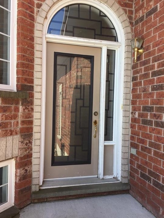 This is an example of a small transitional front door in Other with red walls, concrete floors, a single front door, a brown front door and grey floor.