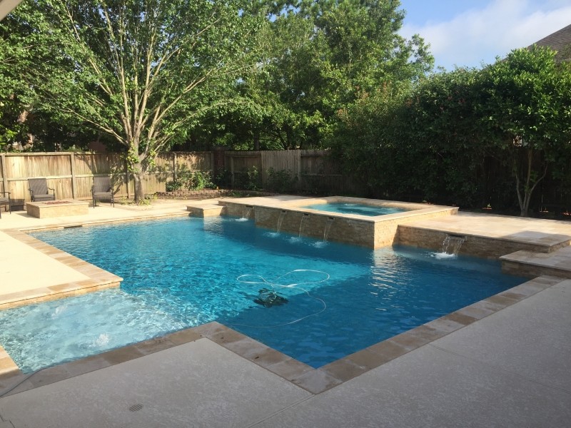 Design ideas for a large transitional backyard custom-shaped pool in Houston with a hot tub and stamped concrete.