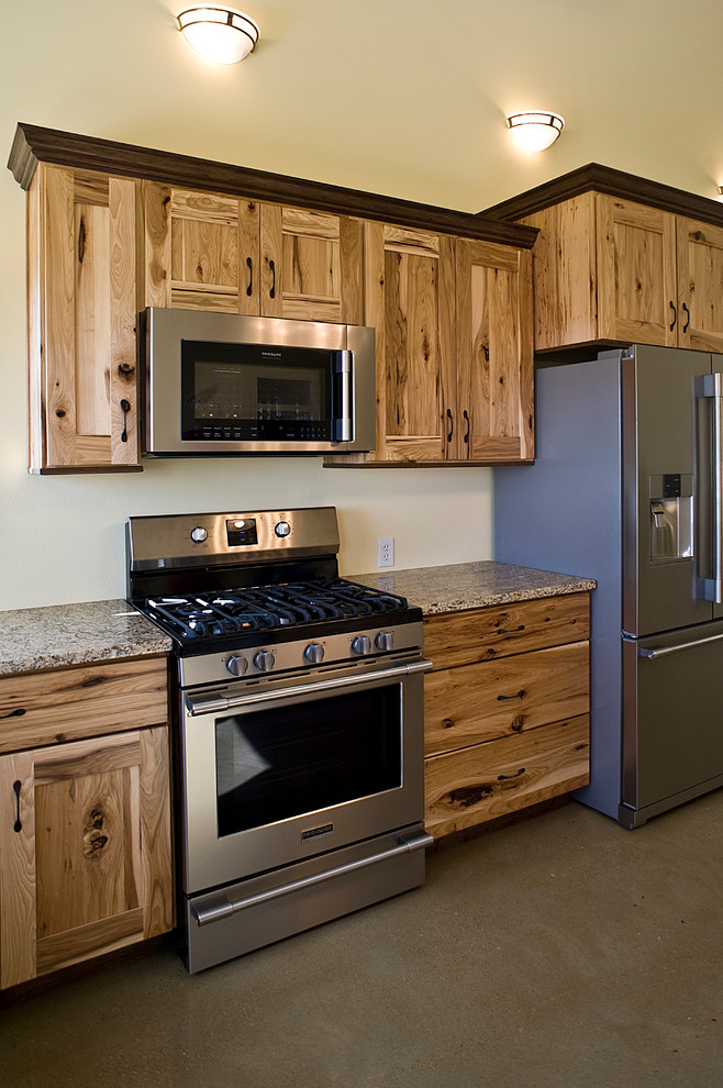 Inspiration for a mid-sized rustic l-shaped concrete floor eat-in kitchen remodel with an undermount sink, shaker cabinets, light wood cabinets, granite countertops, stainless steel appliances and an island