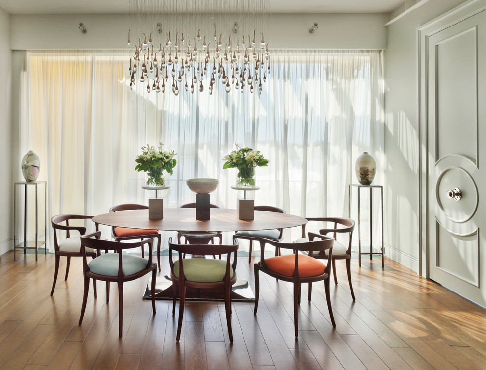 This is an example of a contemporary separate dining room in Moscow with grey walls, medium hardwood floors and orange floor.