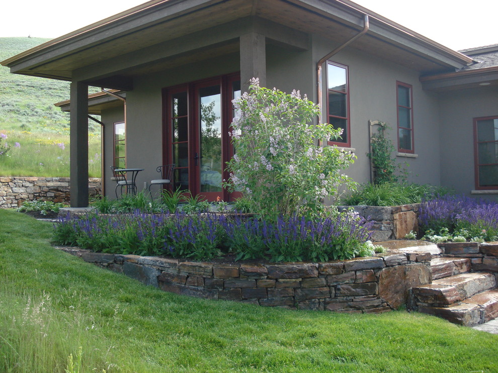 This is an example of a small traditional backyard full sun formal garden for spring in Boise with a fire feature and natural stone pavers.