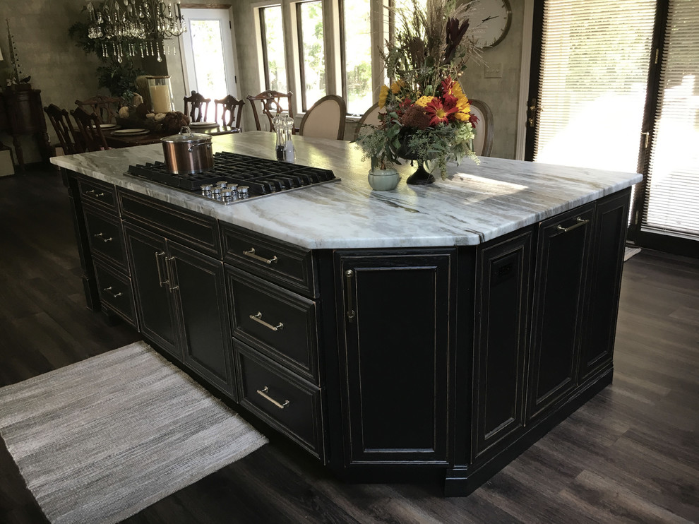 Example of a large transitional u-shaped laminate floor and gray floor eat-in kitchen design with an undermount sink, recessed-panel cabinets, white cabinets, granite countertops, white backsplash, ceramic backsplash, stainless steel appliances, an island and black countertops