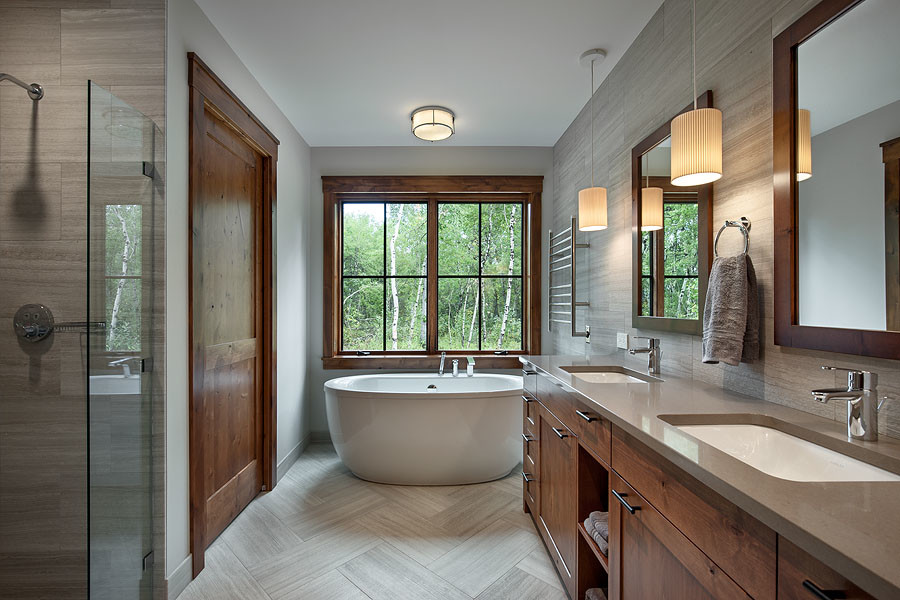 Example of a large transitional master gray tile and marble tile marble floor and gray floor drop-in bathtub design with shaker cabinets, medium tone wood cabinets, a two-piece toilet, white walls, an undermount sink, quartz countertops, a hinged shower door and gray countertops