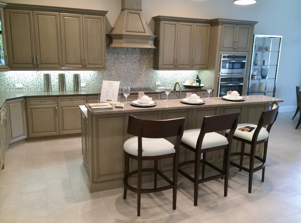 Mid-sized transitional single-wall marble floor eat-in kitchen photo in Tampa with an undermount sink, raised-panel cabinets, beige cabinets, recycled glass countertops, multicolored backsplash, mosaic tile backsplash, stainless steel appliances and a peninsula