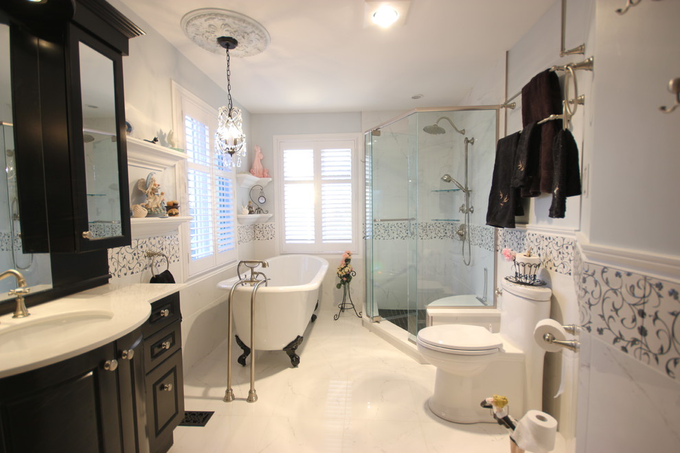 This is an example of a traditional bathroom in Ottawa with an undermount sink, raised-panel cabinets, dark wood cabinets, quartzite benchtops, a claw-foot tub, a corner shower, a one-piece toilet, white tile and porcelain tile.