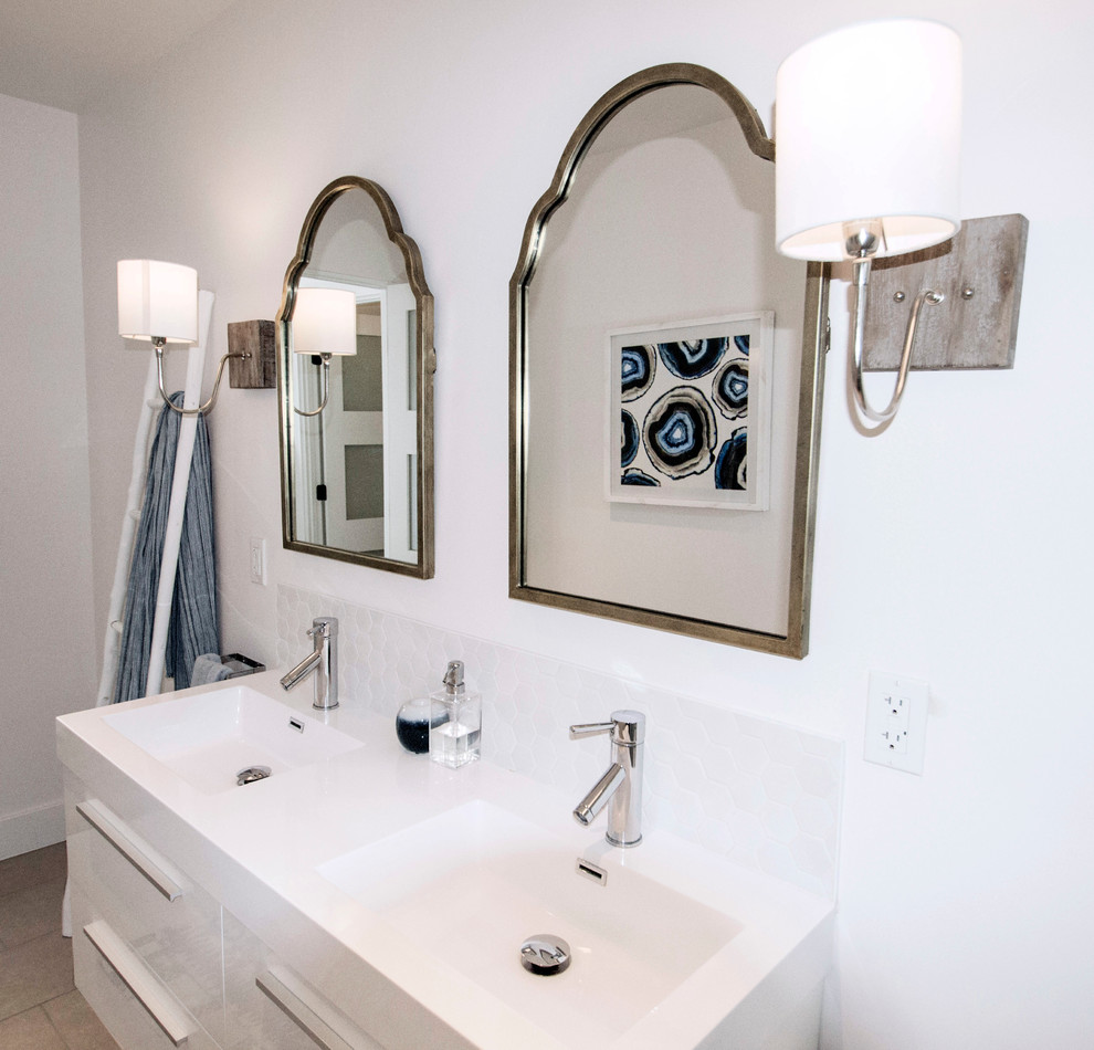 Design ideas for a mid-sized contemporary bathroom in San Diego with flat-panel cabinets, a one-piece toilet, porcelain floors, an integrated sink, engineered quartz benchtops, white cabinets, white tile and white walls.