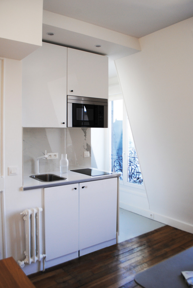 Aménagement d'une petite cuisine ouverte linéaire classique avec un évier encastré, un placard à porte affleurante, des portes de placard blanches, un plan de travail en stratifié, une crédence blanche, une crédence en céramique et aucun îlot.
