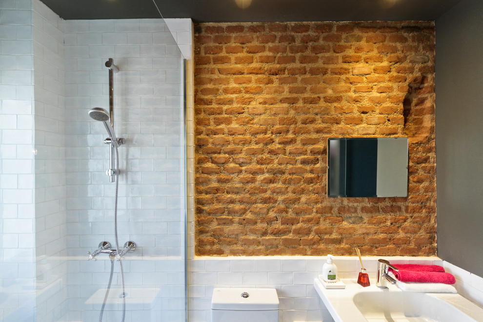 Inspiration for a large industrial master bathroom in Madrid with a curbless shower, a two-piece toilet, multi-coloured walls and an integrated sink.