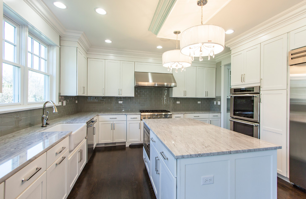 Mid-sized transitional u-shaped dark wood floor open concept kitchen photo in Chicago with a farmhouse sink, shaker cabinets, white cabinets, quartzite countertops, gray backsplash, subway tile backsplash, stainless steel appliances and an island