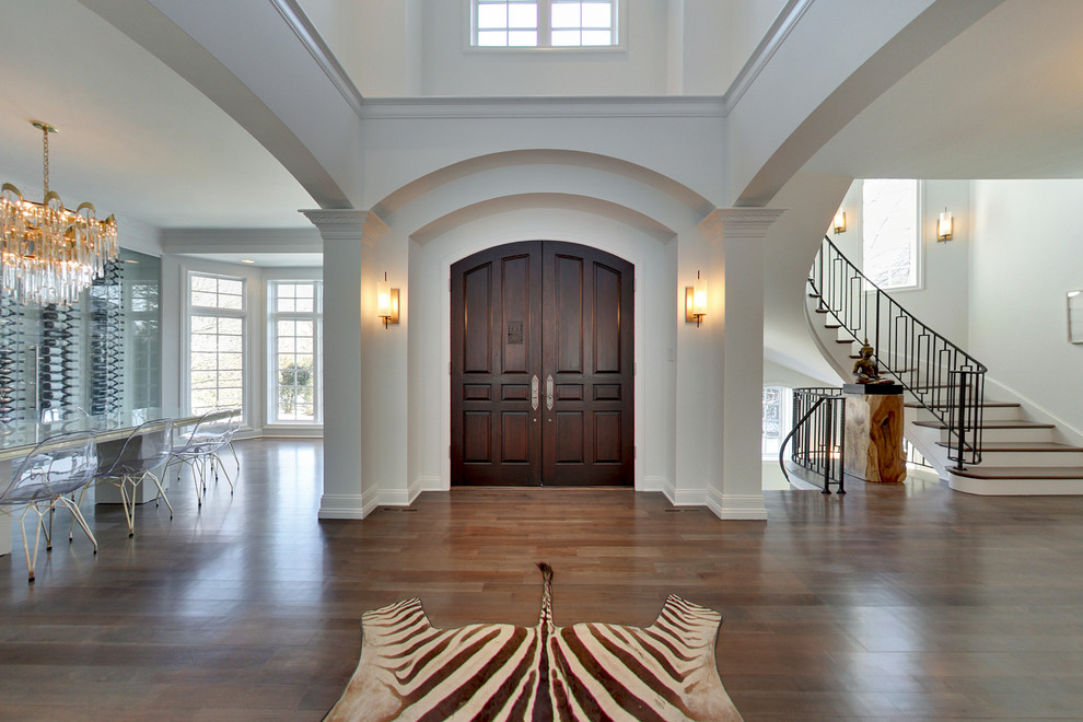 Design ideas for an expansive contemporary foyer in Minneapolis with white walls, dark hardwood floors, a double front door, a dark wood front door and brown floor.