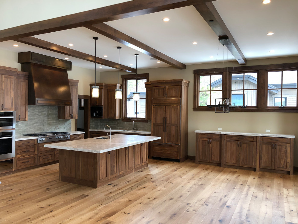 Mid-sized arts and crafts l-shaped eat-in kitchen in Sacramento with an undermount sink, shaker cabinets, medium wood cabinets, quartzite benchtops, green splashback, glass tile splashback, panelled appliances, with island, brown floor and white benchtop.