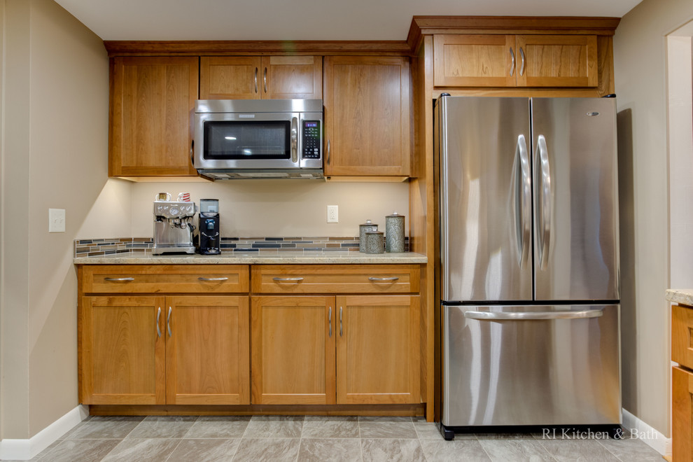 Inspiration for a mid-sized transitional u-shaped porcelain tile enclosed kitchen remodel in Providence with an undermount sink, shaker cabinets, medium tone wood cabinets, granite countertops, multicolored backsplash, glass tile backsplash, stainless steel appliances and no island