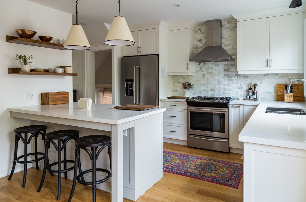 Transitional l-shaped kitchen in Toronto with a double-bowl sink, shaker cabinets, white cabinets, quartz benchtops, multi-coloured splashback, stone tile splashback, stainless steel appliances and with island.
