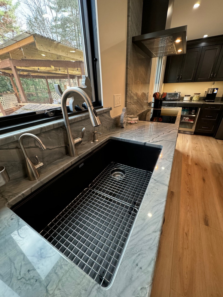 Eat-in kitchen - mid-sized transitional u-shaped laminate floor and brown floor eat-in kitchen idea in Boston with an undermount sink, shaker cabinets, brown cabinets, quartz countertops, black appliances, an island and multicolored countertops