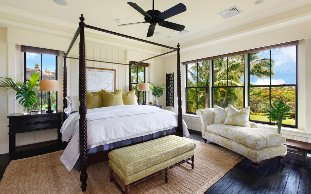 This is an example of a tropical bedroom in Hawaii with beige walls, dark hardwood floors and black floor.